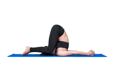 Low angle view of woman lying on floor against white background