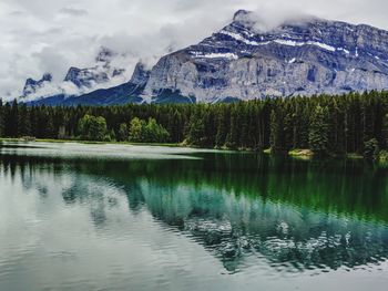 Scenic view of lake by snowcapped mountains against sky