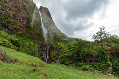 Scenic view of waterfall against sky