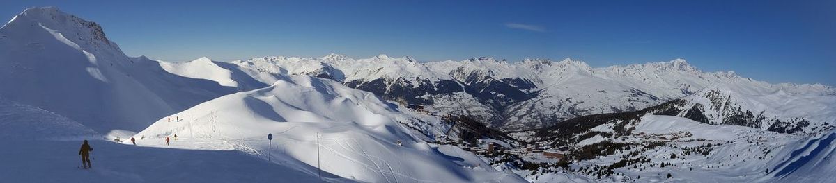 Scenic view of snowcapped mountain against blue sky