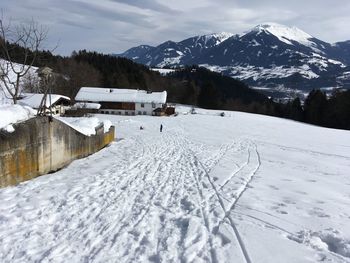 Scenic view of snow covered field and mountains against sky