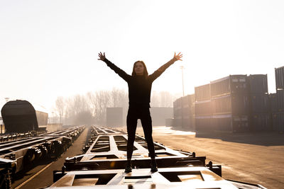 Young female runner takes a break on a freight train in the commercial port in the morning