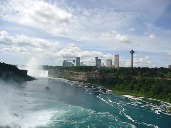 Scenic view of sea by buildings against sky