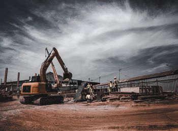 Cranes at construction site against sky