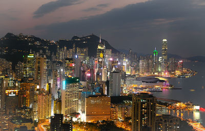 Illuminated buildings in city against sky at night