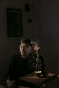 Portrait of young man sitting on table