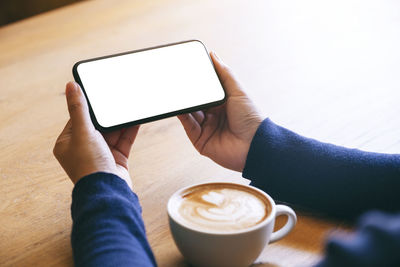 Low section of woman holding coffee cup