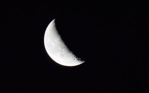 Low angle view of half moon against sky at night