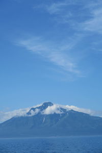 Scenic view of snowcapped mountains against blue sky