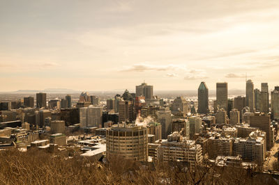 Aerial view of buildings in city against sky