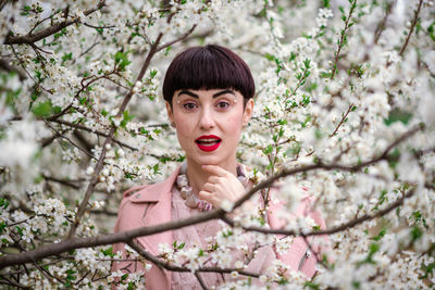 Portrait of young woman with cherry blossoms in spring