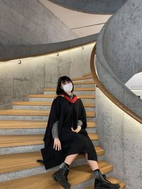 Full length of young graduate standing in tunnel