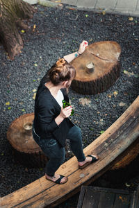 High angle view of man sitting on wood