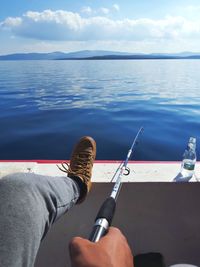 Low section of person in sea against sky