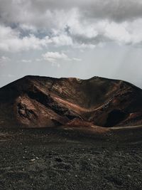 Scenic view of mountain against cloudy sky