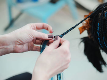 Midsection of woman tying dyed hair