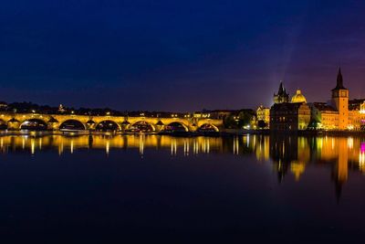 Illuminated charles bridge over river against sky at night