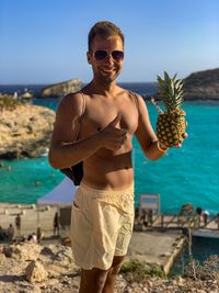 Young man wearing sunglasses standing on beach