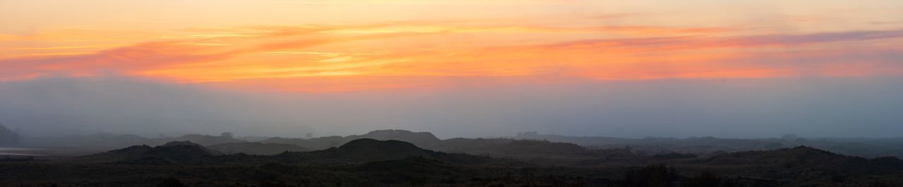 Scenic view of silhouette mountains against sky during sunset