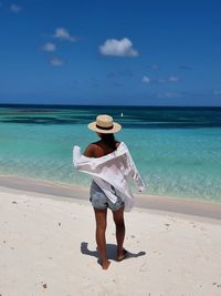 Rear view of man on beach against sky