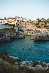 Buildings by sea against clear sky