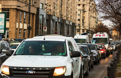 Vehicles on road by buildings in city