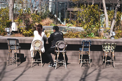 Rear view of people sitting on table