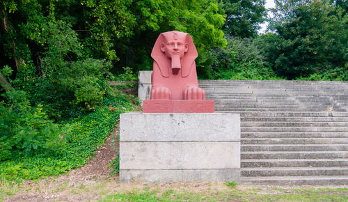 Statue against trees and plants in park