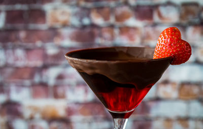 Chocolate dipped valentine's day cocktail with a heart shaped strawberry garnish