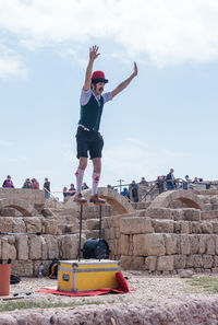 Woman jumping against sky