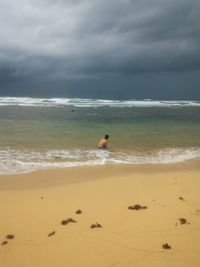 Scenic view of beach against cloudy sky