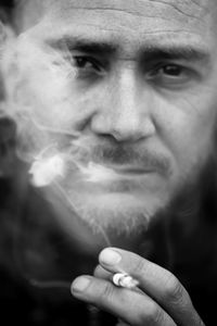 Close-up portrait of man smoking cigarette