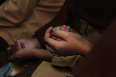 Close-up of hands playing on bed