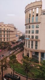 High angle view of buildings by street against sky