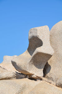 Close-up of rocks against clear blue sky