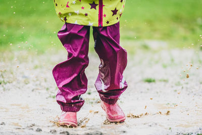 Low section of child playing in puddle
