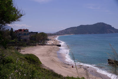Scenic view of sea by buildings against sky