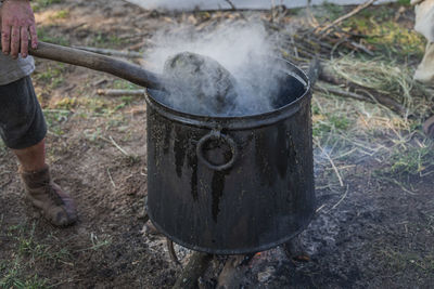 Close-up of man preparing food on barbecue grill