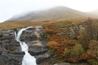 Scenic view of waterfall against sky