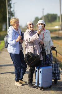 Group senior women take a self-portrait on platform  for a train to travel during covid-19 pandemic