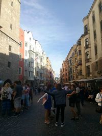 People on street in city against sky