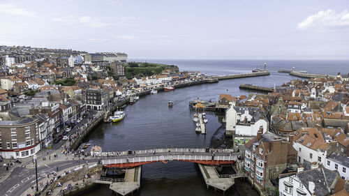 High angle view of buildings by sea against sky