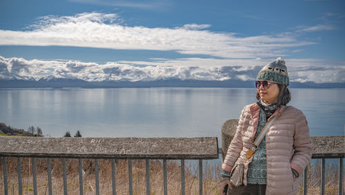 Portrait of woman standing against lake