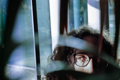 Close-up portrait of young man against window