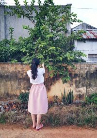 Rear view of woman standing against trees