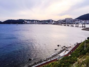 Scenic view of beach by city against sky