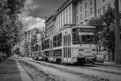 Train on railroad tracks in city against sky