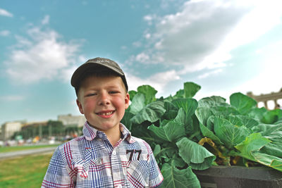 Portrait of smiling boy standing against sky