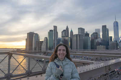 Portrait of young woman standing in city