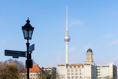 Street light and road sign against fernsehturm in city